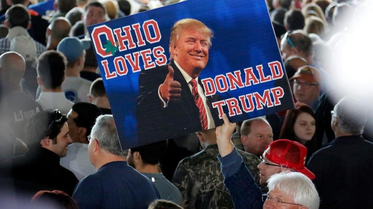 A supporter of Republican presidential candidate, Donald Trump holds a sign during a plane-side rally at Youngstown-Warren Regional Airport in Vienna, Ohio, Monday, March 14, 2016.