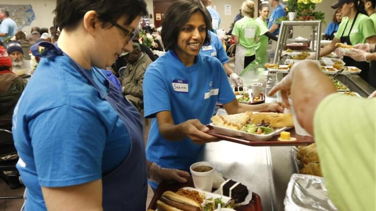 Volunteers help in the serving line at the Shepherd’s Table Soup Kitchen in Raleigh.