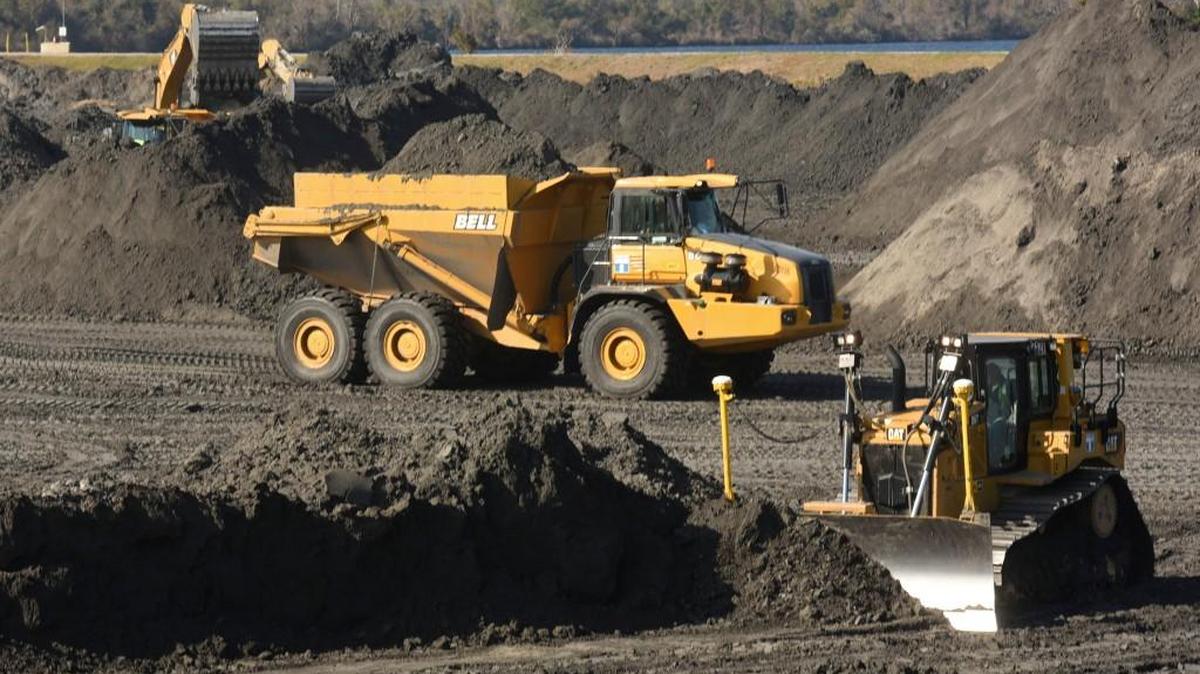 In this Tuesday, Nov. 14, 2017 photo, crews with Duke Energy continue to remove coal ash from the old coal ponds at the Sutton Plant, in Wilmington, N.C. The coal ash is being transported to a new lined landfill site that when finished will be a mile long.