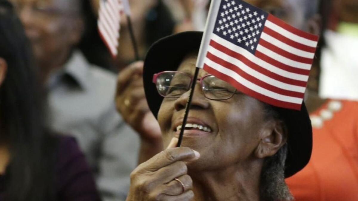Ambrozine Bastine McLennon, of Jamaica, waves an American flag after becoming a U.S. citizen during a naturalization ceremony on Sept. 30 in Miami.