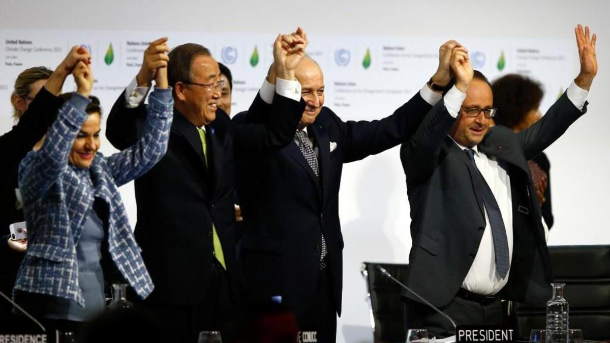 Leaders celebrate the adoption of an agreement that for the first time asks all countries to reduce or rein in their greenhouse gas emissions.