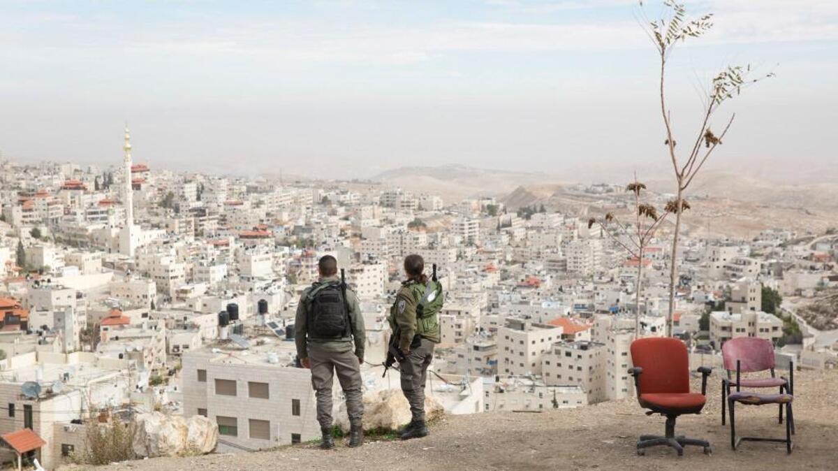 In this Sunday, Dec. 10, 2017 photo, Israeli border police officers overlooking the Arab neighborhood of Issawiyah in Jerusalem. When President Donald Trump recognized contested Jerusalem as Israel's capital, he said he was simply acknowledging reality, but failed to mention Palestinian residents, or 37 percent of the city's population.