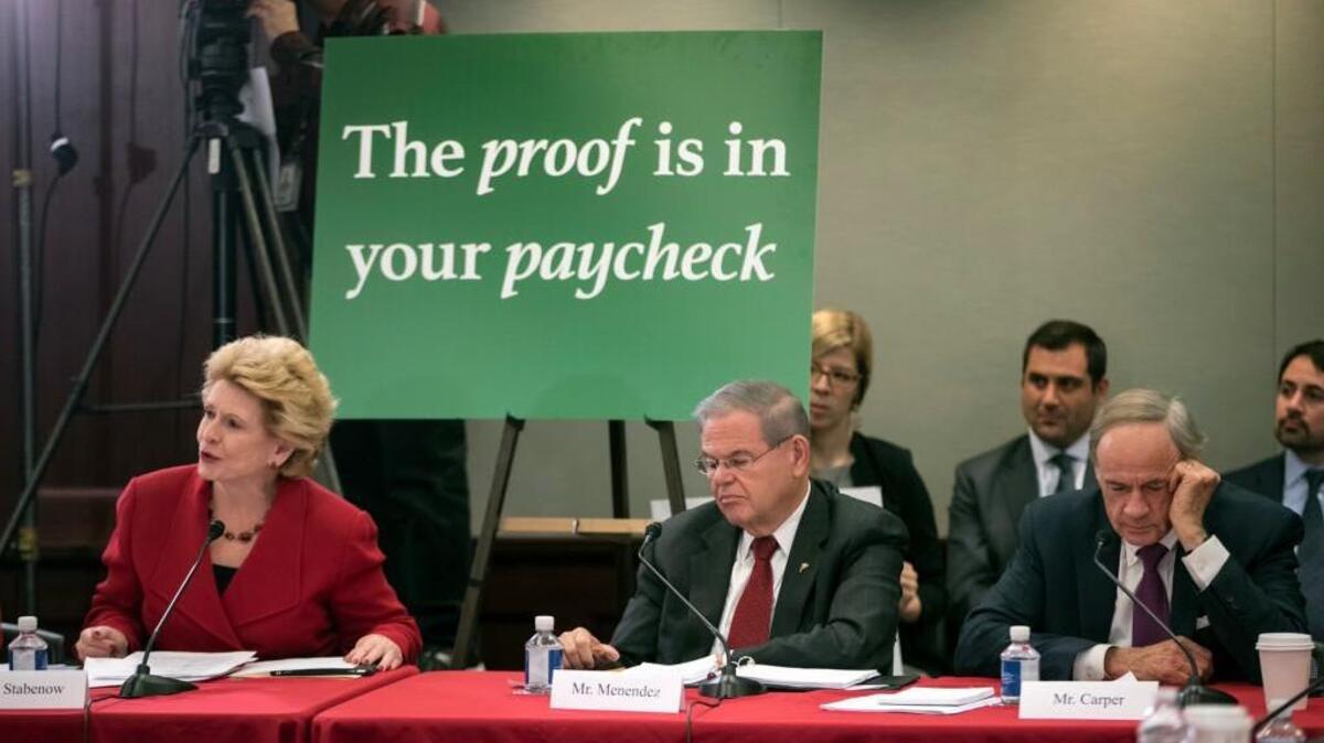 Tax bill conferee Sen. Debbie Stabenow, D-Mich., left, joined by Sen. Bob Menendez, D-N.J., center, and Sen. Tom Carper, D-Del., all members of the tax-writing Senate Finance Committee, uses charts as she opposes the sweeping GOP tax plan, on Capitol Hill in Washington, Wednesday, Dec. 13, 2017.
