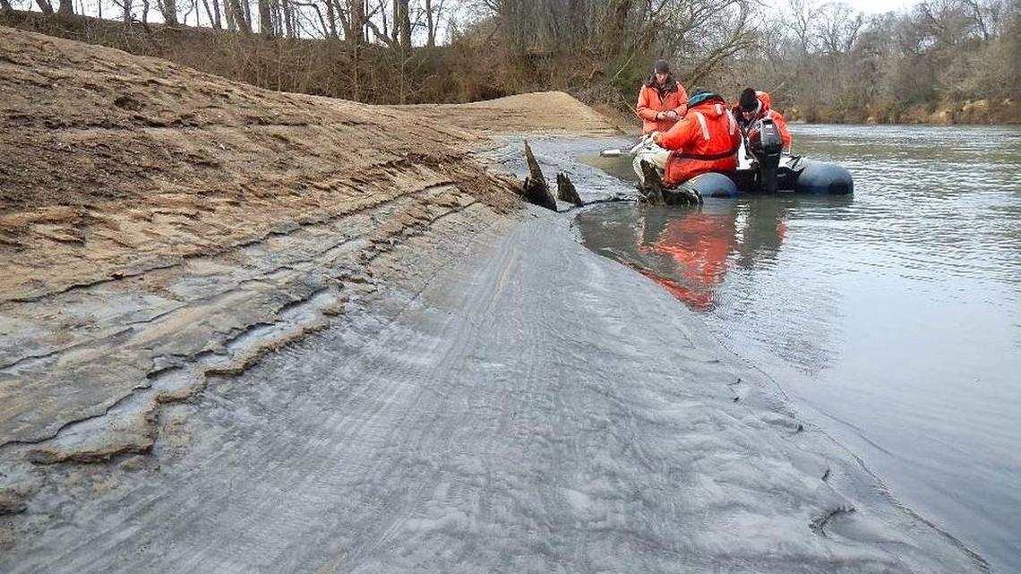 From left, Tom Augspurger and John Fridell of the U.S. Fish and Wildlife Service and Rick Smith of Duke Energy take a core sample during a Feb. 8, 2014, reconnaissance of the Dan River coal ash spill.