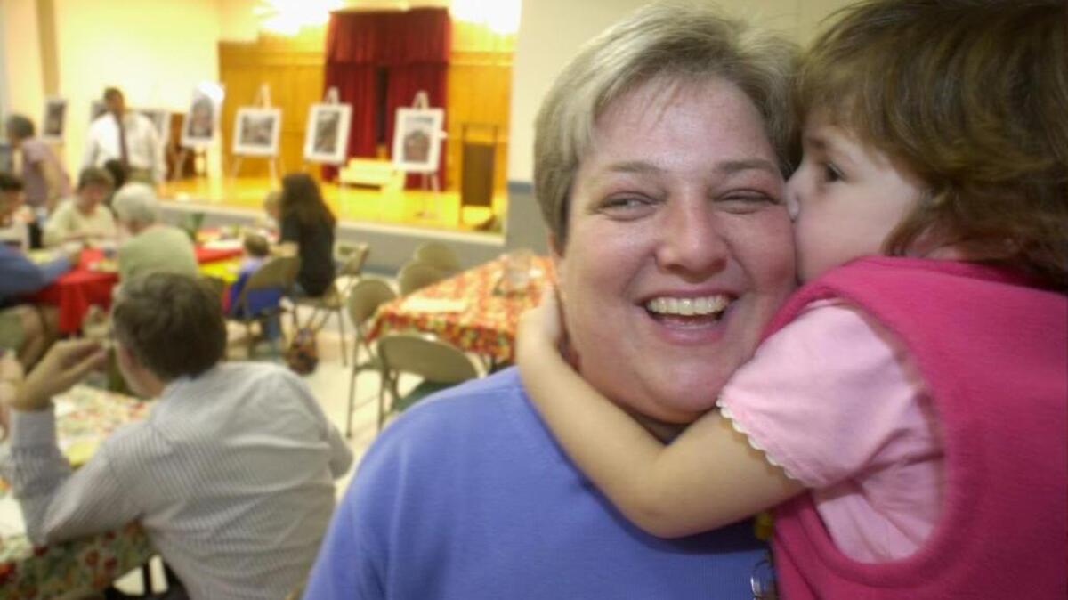 
Nancy Petty, pastor of Pullen Memorial Baptist Church, gets a kiss from her daughter Nora. The picture is from 2002.

