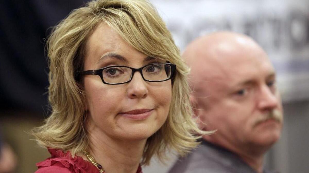 Former Arizona Rep. Gabrielle Giffords, accompanied by her husband, retired astronaut and combat veteran Capt. Mark Kelly, takes part in a news conference at the Millyard Museum, Friday, July 5, 2013, in Manchester, N.H. Three years after being shot in the head, Giffords is calling on New Hampshire's political leaders to have courage in the fight to expand background checks on gun purchases.