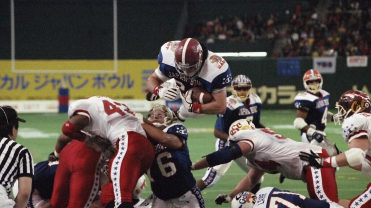In this Jan. 12, 1992 photo, East's Kevin Turner, of Alabama, dives over the top for a touchdown in the fourth quarter of the Japan Bowl, the American collegiate all-star football game, at the Tokyo Dome. A fullback at Alabama before playing eight years in the NFL for New England and Philadelphia, Kevin Turner was 46 when he died in 2016. He had been diagnosed with amyotrophic lateral sclerosis, known as ALS or Lou Gehrig's disease, but after studying his brain researchers declared that it was actually CTE.