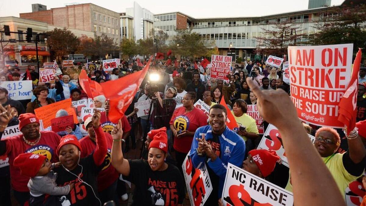 Protesters gather to support raising the minimum wage to $15/hour in Durham, N.C. Tuesday, November 10, 2015. About 150 supporters gathered at the City Plaza to listen to speeches before marching to Durham City Hall about two blocks away.