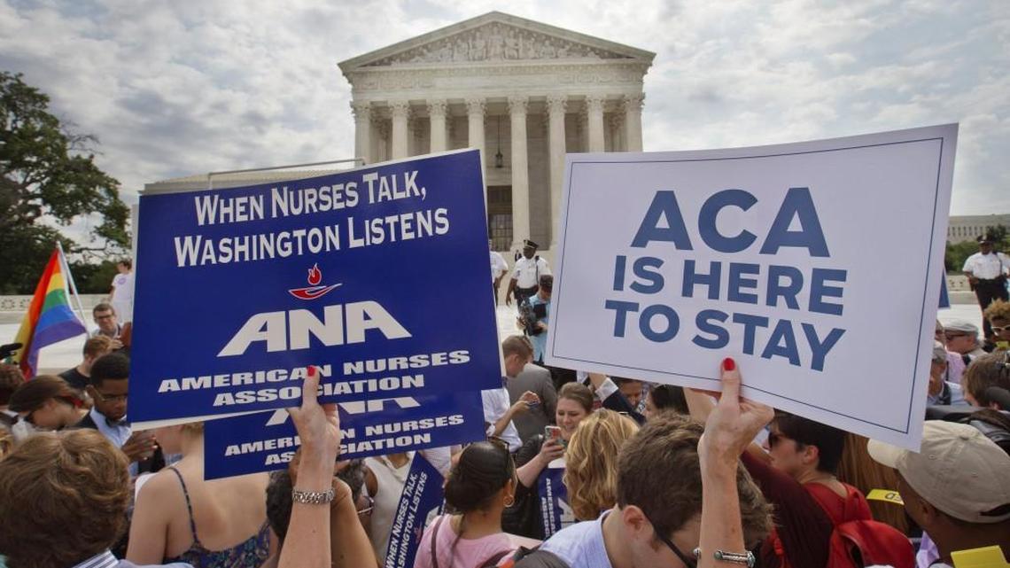 In this June 25, 2015, file photo, supporters of the Affordable Care Act hold up signs as the opinion for health care is reported outside of the Supreme Court in Washington.