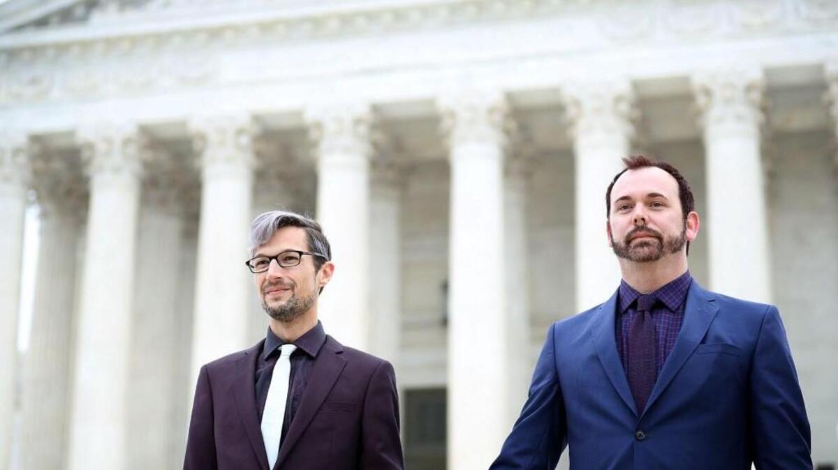 Charlie Craig (L) and Dave Mullins acknowledge supporters before entering the Supreme Court building December 5, 2017 in Washington, DC. Craig and Mullins filed a complaint with the Colorado Civil Rights Commission after conservative Christian baker Jack Phillips refused to sell them a wedding cake for their same-sex ceremony.