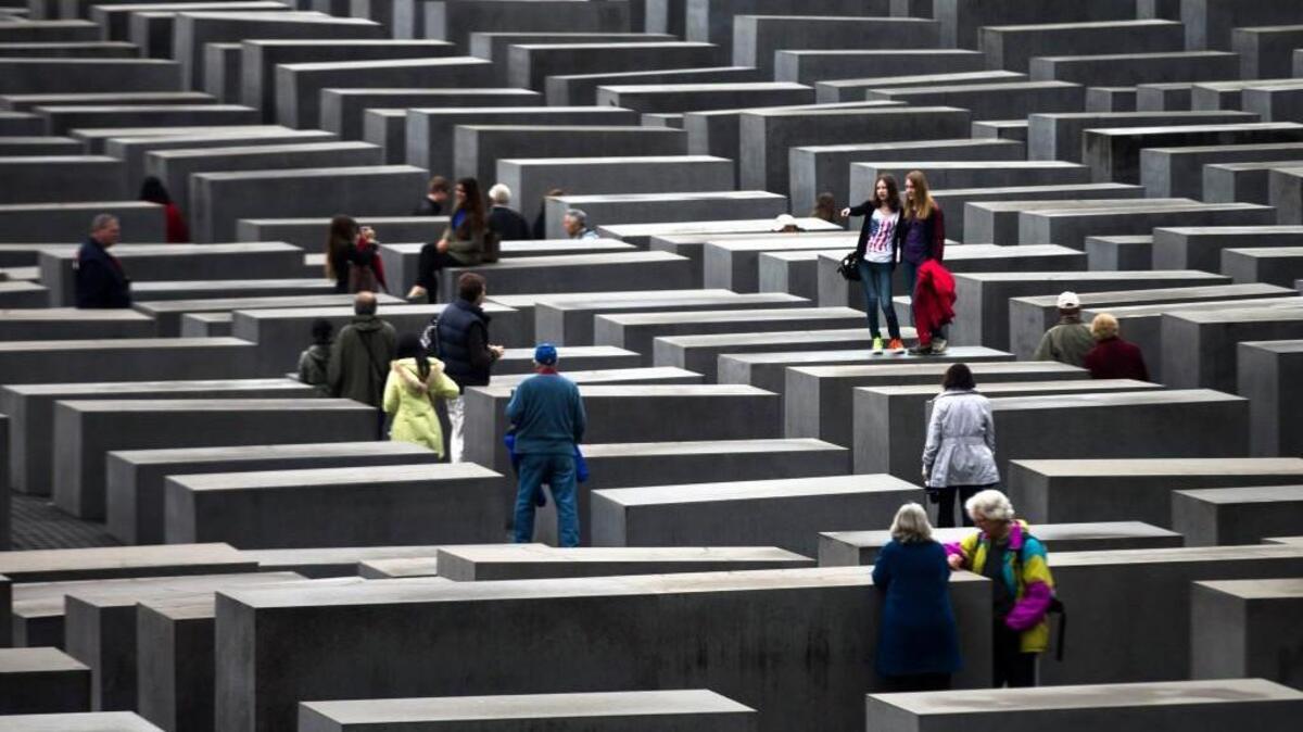 Tourists visit the Holocaust Memorial on a rainy day in Berlin in 2013.