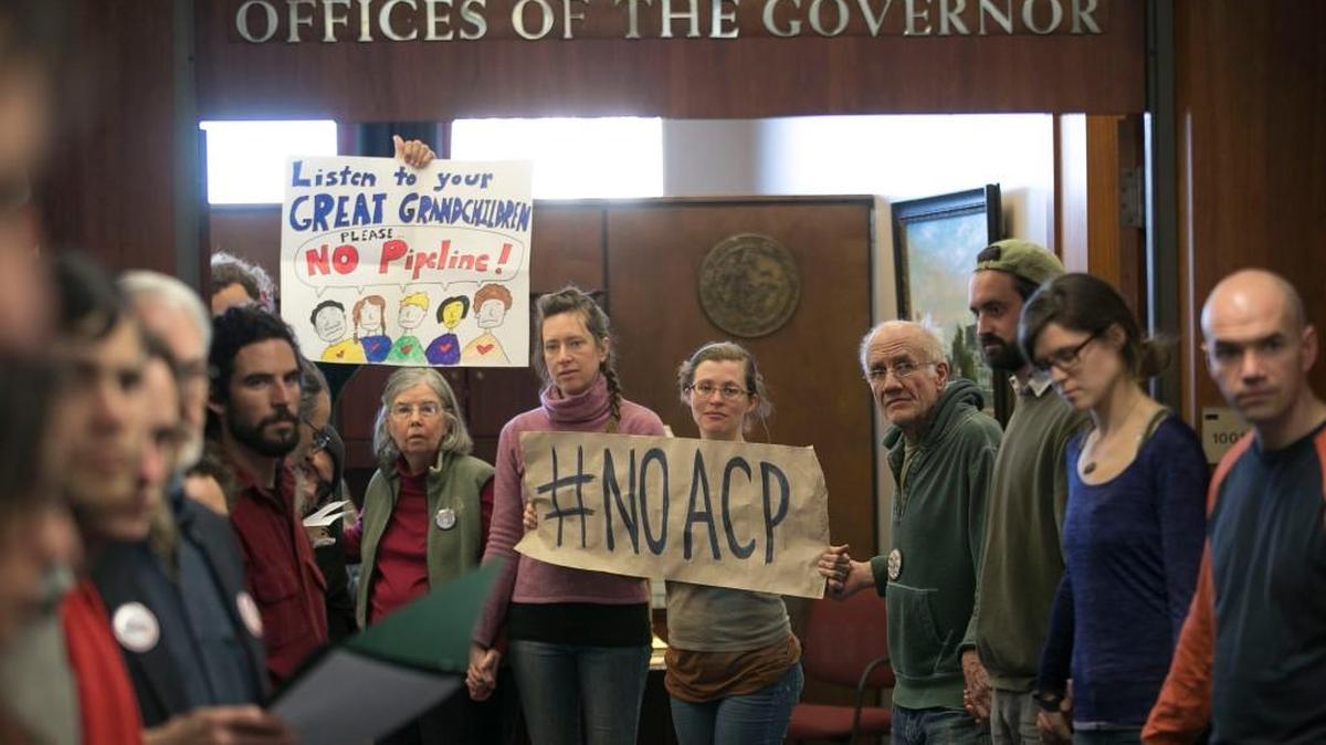 Protesters hold signs protesting the Atlantic Coast Pipeline during a sit-in at North Carolina Governor Roy Cooper’s office February 2018 in Raleigh, N.C.