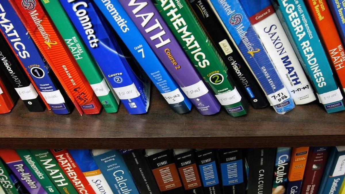 Rows of current NC school math books line the shelves of the sample library for student books in the State Textbook Warehouse off Reedy Creek Rd.