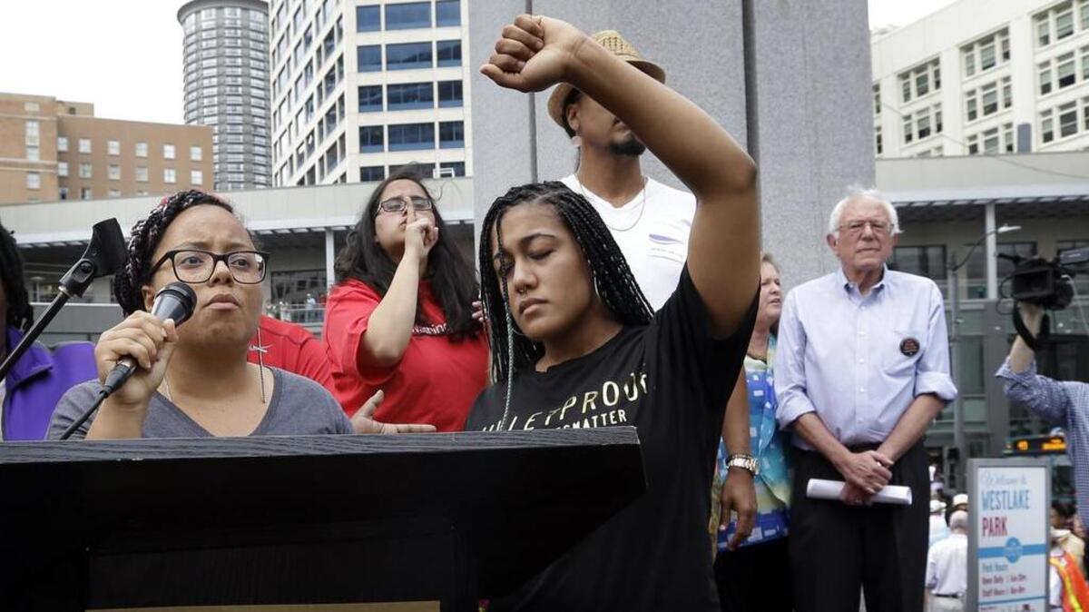 
Marissa Johnson, left, speaks as Mara Jacqueline Willaford holds her fist overhead and Democratic presidential candidate Sen. Bernie Sanders, I-Vt., stands nearby as the two women take over the microphone at a rally in downtown Seattle. The women are co-founders of the Seattle chapter of Black Lives Matter.
