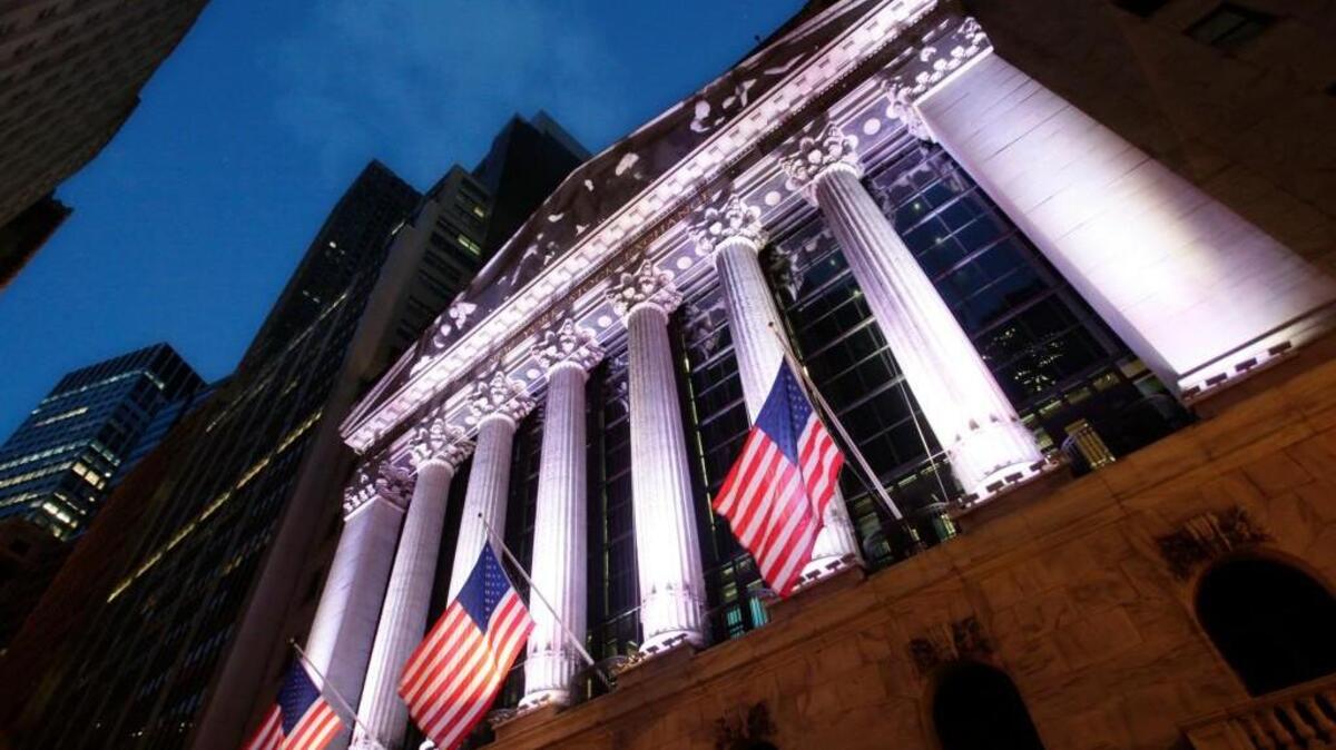 In this Oct. 8, 2014, file photo, American flags fly in front of the New York Stock Exchange.