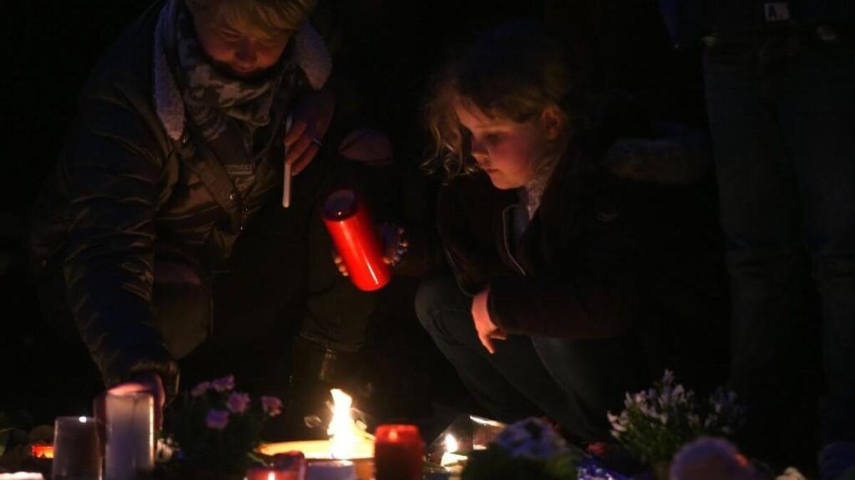 People light candles to pay tribute to the victims of the Brussels attacks on the Place de la Bourse in central Brussels three days after a triple bomb attack by the Islamic State.