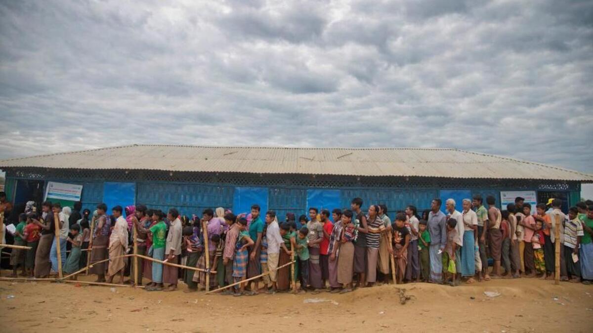 Rohingya Muslims, who crossed over from Myanmar into Bangladesh, wait in queues to receive aid at Kutupalong refugee camp in Ukhiya, Bangladesh, Wednesday, Nov. 15, 2017.