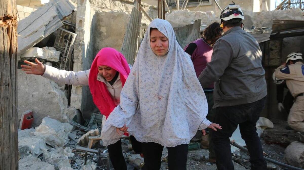 Syrian girls run after a reported Syrian regime air strike in a rebel-controlled area in Aleppo