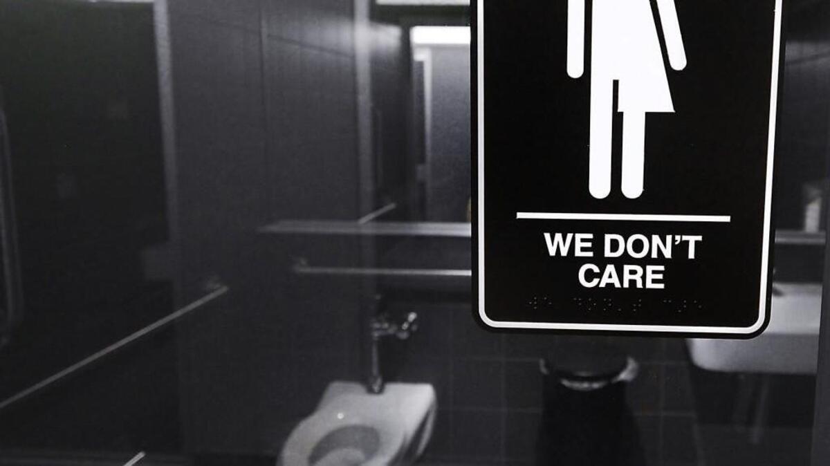 Gender neutral signs are posted in the 21C Museum Hotel public restrooms in Durham.
