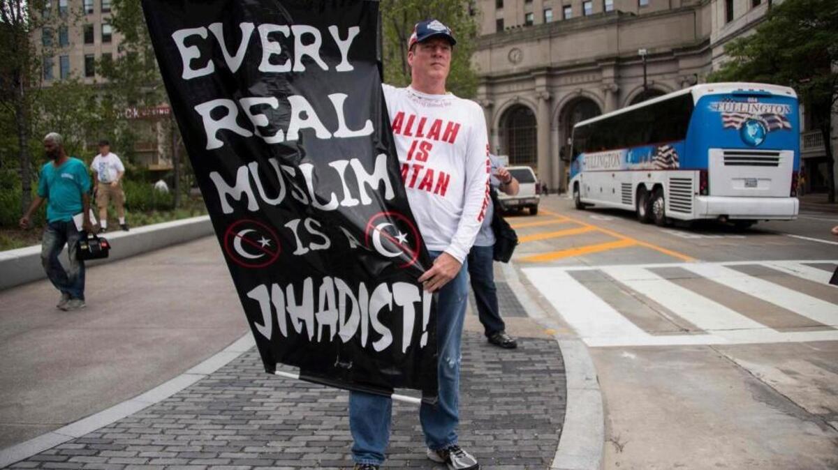 A Donald Trump supporter holds up an anti-Muslim poster during the Republican National Convention in Cleveland.