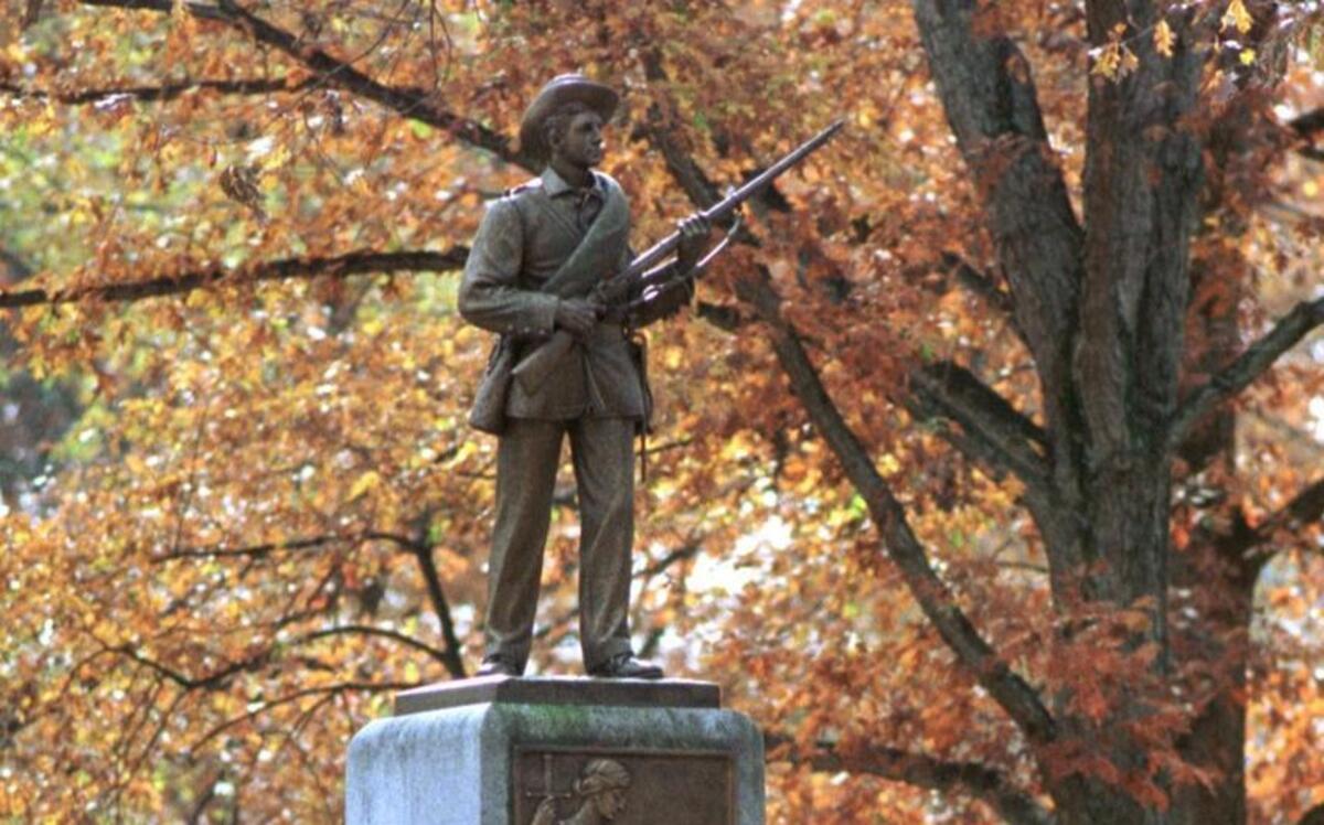Visitors stop to inspect the campus monument dedicated to UNC alums or students who fought in the Civil War.