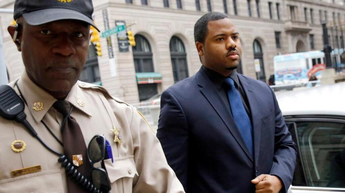 Officer William Porter, right, one of six Baltimore city police officers charged in connection to the death of Freddie Gray, enters the courthouse for the third day of jury deliberations Wednesday in Baltimore.