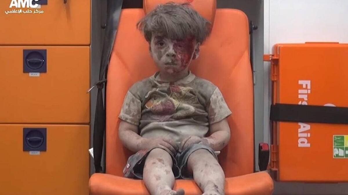A Syrian child sits in an ambulance after a house was destroyed in an airstrike in Aleppo. Five children were killed.