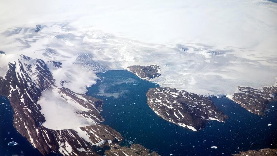 A glacier calves icebergs into a fjord off the Greenland ice sheet in southeastern Greenland.