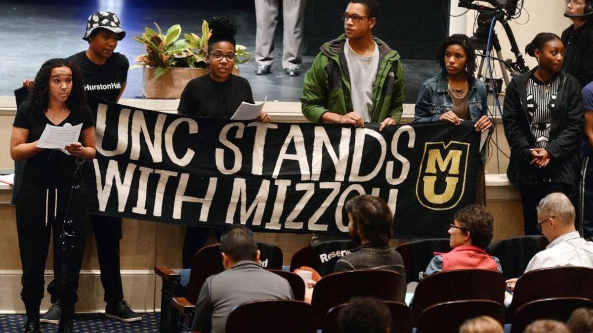 UNC senior June Beshea reads a list of demands to a full house at Memorial Hall on the campus of UNC in Chapel Hill. A group of about 50 protesters left their seats and took control of the microphone to address the audience with a list of demands during a Town Hall meeting.