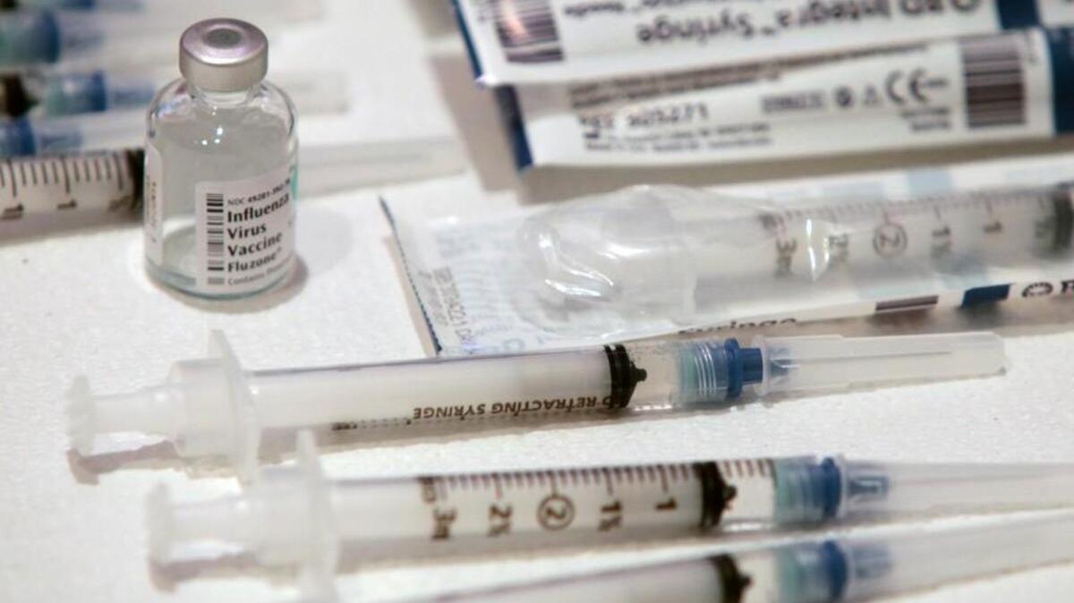 A bottle of Influenza Virus Vaccine, left, and stacks of syringes await a line of Murdoch Center employees in the Chapel of the Murdoch Center, Butner, NC Wednesday afternoon, Oct. 9, 2013.