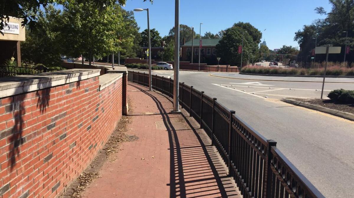 The roundabout at Pullen Road funnels pedestrians into narrow, fenced-in pathways at the edge.
