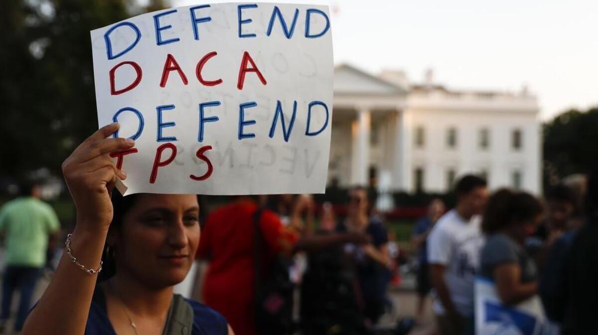 A woman holds up a sign that reads "Defend DACA Defend TPS" during a rally supporting Deferred Action for Childhood Arrivals, or DACA, outside the White House in Washington, Monday, Sept. 4, 2017. TPS stands for "Temporary Protected Status." A plan President Donald Trump is expected to announce Tuesday for young immigrants brought to the country illegally as children was embraced by some top Republicans on Monday and denounced by others as the beginning of a "civil war" within the party.