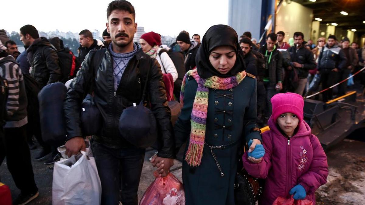 Migrants and refugees disembark from a ferry after arriving to the port of Piraeus, near Athens, Greece. More than a million people hoping to escape war and poverty made their way into Europe last year.