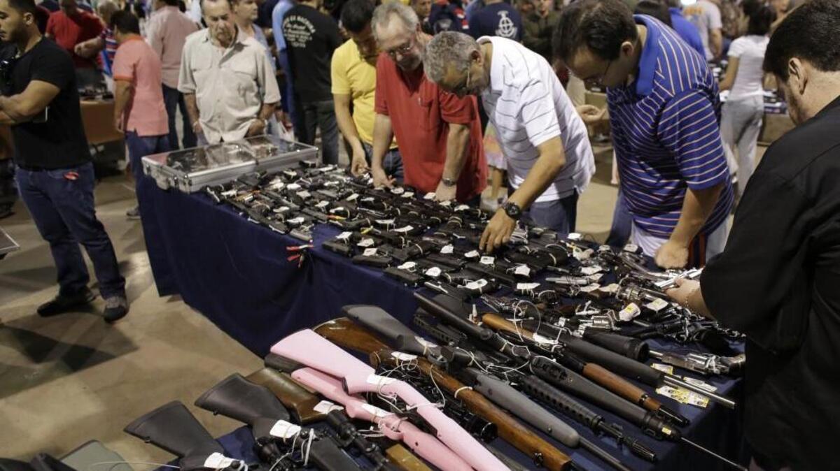 People shop for guns at a gun show hosted by Florida Gun Shows in Miami.