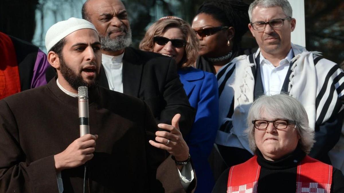 Imam Mohamed AbuTaleb, left, speaks to the crowd as Rabbi Eric M. Solomon, upper right, spiritual leader of Beth Meyer Synagogue and Pastor Nancy E. Petty, right, of Pullen Memorial Baptist Church look on during an interfaith service at the Islamic Association of Raleigh on Dec. 11, 2015.