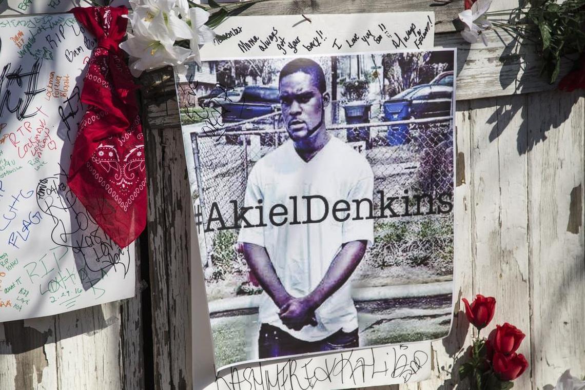 A man who identified himself as A. Wilson pays tribute to Akiel Denkins, 24, at a makeshift memorial near the intersection of Bragg and South East streets in Raleigh. Denkins died during a Raleigh police officer involved shooting.