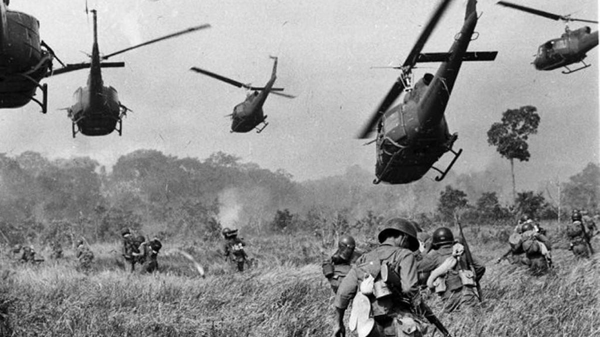 Hovering U.S. Army helicopters pour machine gun fire into a tree line to cover the advance of South Vietnamese ground troops in an attack on a Viet Cong camp 18 miles north of Tay Ninh, northwest of Saigon near the Cambodian border, in Vietnam in March of 1965. (