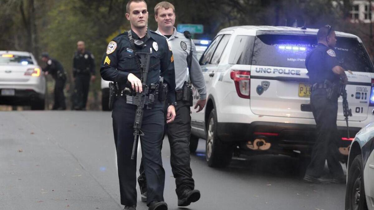 UNC-CH police officers return to their patrol cars after a call about a man with a rifle on Battle Lane adjacent to the UNC-CH campus.
