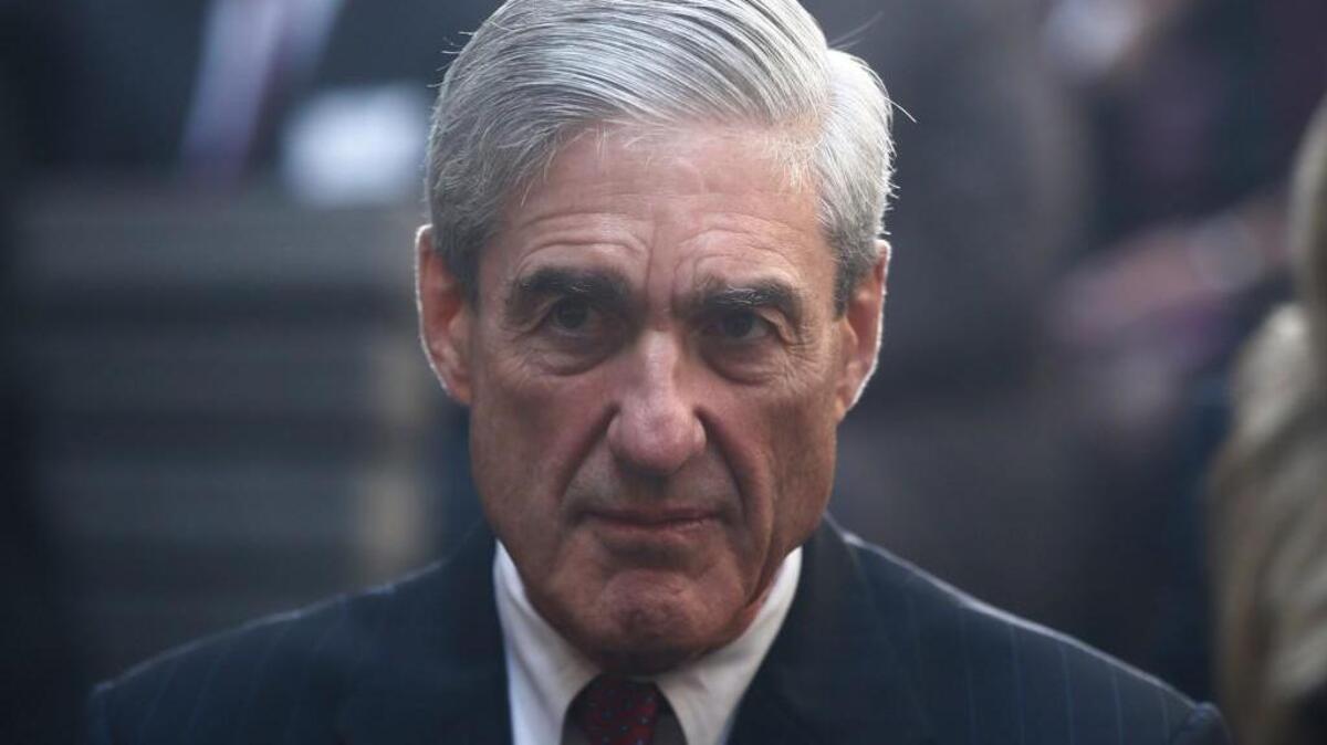 In this Oct. 28, 2013, file photo, former FBI Director Robert Mueller is seated before President Barack Obama and FBI Director James Comey arrive at an installation ceremony at FBI Headquarters in Washington.