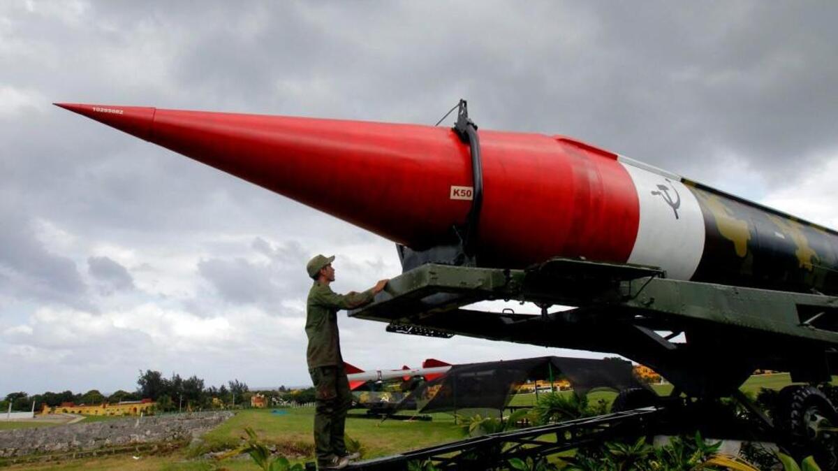 In this Oct. 13, 2012 file photo, a soldier pauses to look at the outer casing of an old empty Soviet missile on exhibit as he works to paint it at the military complex Morro Cabana which is open to tourists in Havana, Cuba. The world stood at the brink of Armageddon for 13 days in October 1962 when President John F. Kennedy drew a symbolic line in the Atlantic and warned of dire consequences if Soviet Premier Nikita Khrushchev dared to cross it.