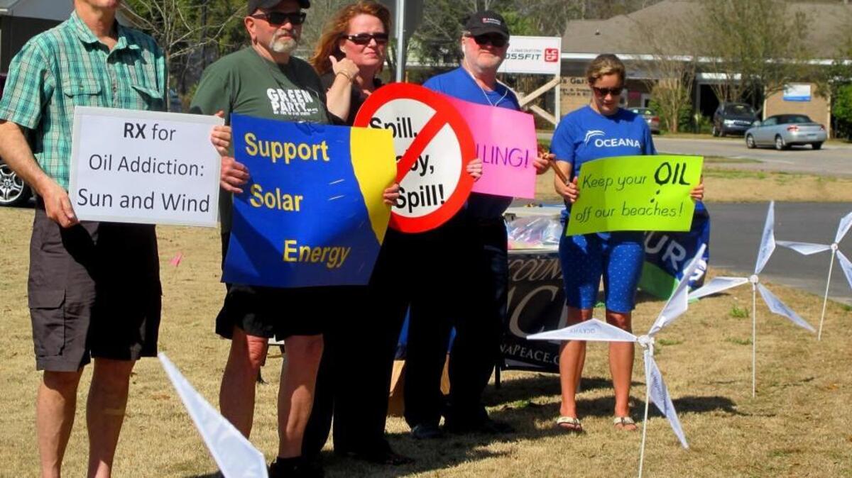 In this 2015 file photo, opponents of opening waters off the Carolinas coast to oil and natural gas exploration hold signs in Mount Pleasant, S.C. They were standing outside a motel where the federal Bureau of Ocean Energy Management held a meeting to take public comment.
