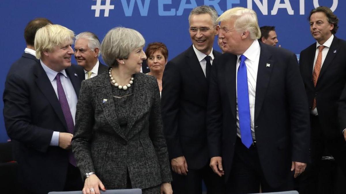 U.S. President Donald Trump jokes with British Foreign Minister Boris Johnson, left, NATO Secretary General Jens Stoltenberg and British Prime Minister Theresa May during a working dinner meeting at the NATO headquarters during a NATO summit of heads of state and government in Brussels on Thursday, May 25.