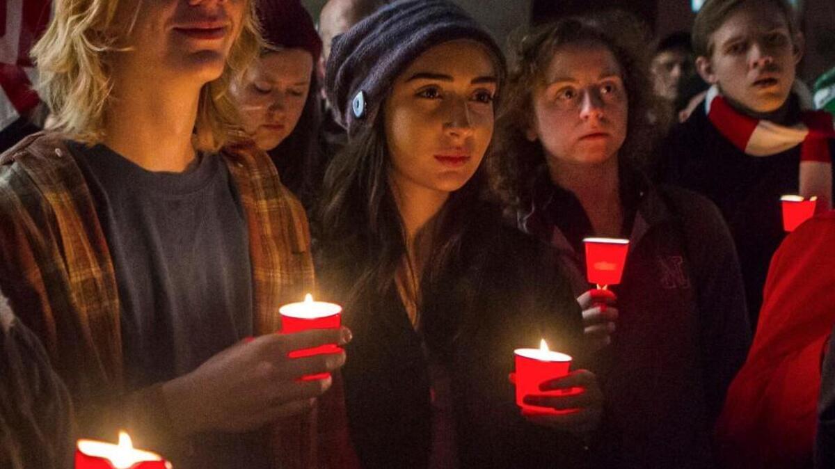 Jayden Card and Luta Mernard listen to a speaker at a candlelight vigil for Syrian refugees at Tower Square in Lincoln, Neb., a week after Nebraska Gov. Pete Ricketts joined other Republican governors, including N.C. Gov. Pat McCrory, expressing concern over federal screening of Syrian refugees who want to enter the United States.