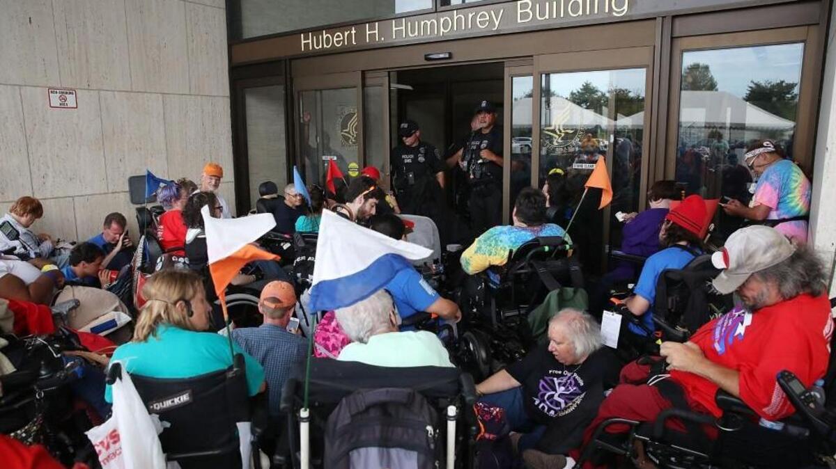 WASHINGTON, DC - SEPTEMBER 26: Disabled protesters block the entrance to the Health and Human Services headquarters located at the Hubert H. Humphrey Building on September 26, 2017 in Washington, DC. The protesters are against the Graham-Cassidy bill that Senate Majority Leader Mitch McConnell (R-KY) scrubbed today after not having enough votes.