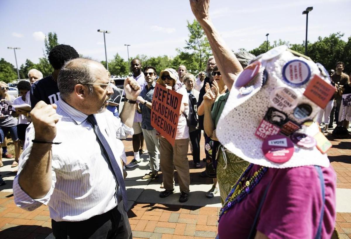 Mark Dorosin, managing attorney at the UNC Center for Civil Rights, left, chants among protestors Aug. 1.