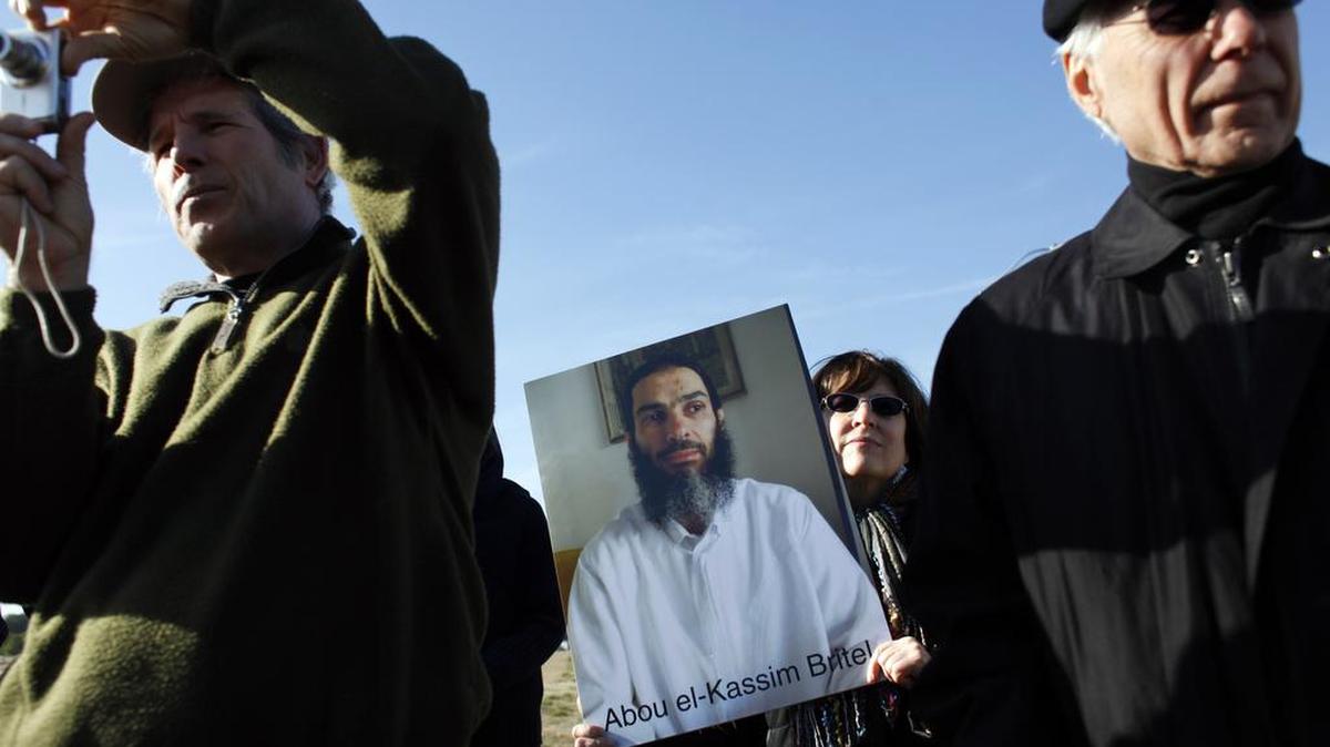 From left, Christian Stalberg, Barbara Zelter and Robert Moore listen during a press conference organized by Stop Torture Now Thursday, January 19, 2012, at the Johnston County airport. Zelter holds a photo of a detainee who is one of the cases detailed in a lengthy report from the UNC law school outlining what a team of lawyers and law students there believe are violations of state and federal laws by the employees of Aero Contractors, Ltd.