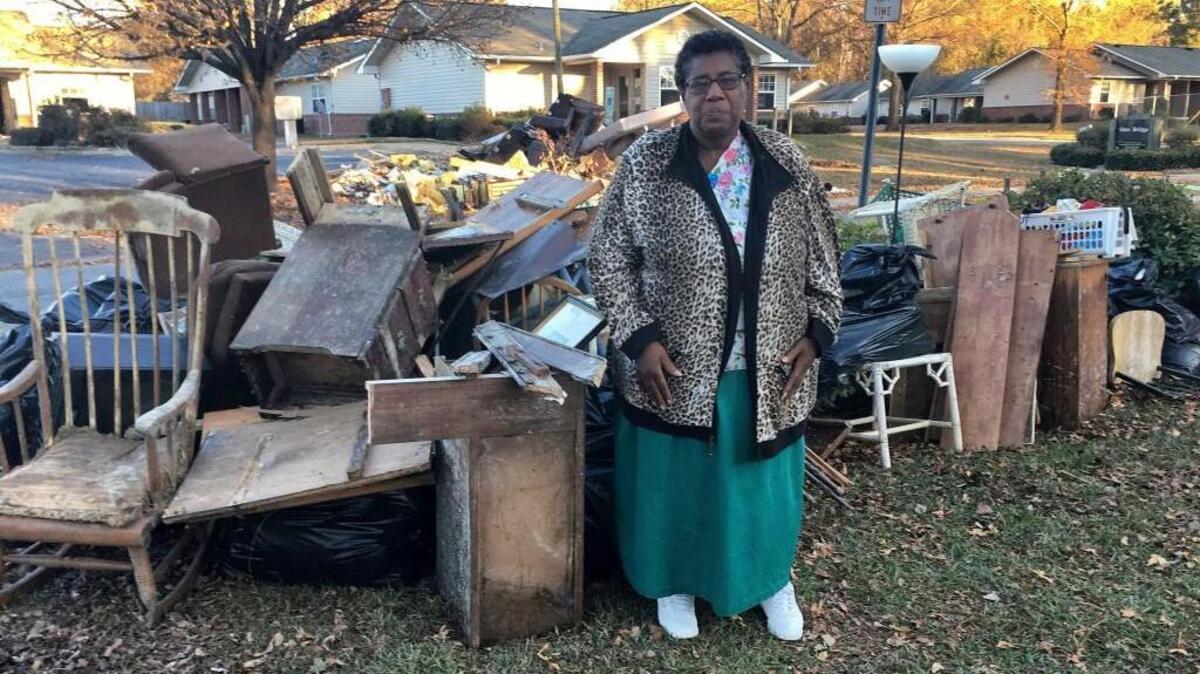 In this Dec. 1, 2016 photo, Dianne Hines stands in front of the mound of furniture and other belongings pulled from her home after Hurricane Matthew, in Princeville. Hines' home was rebuilt after Hurricane Floyd in 1999. This time, she said she's ready to move elsewhere.