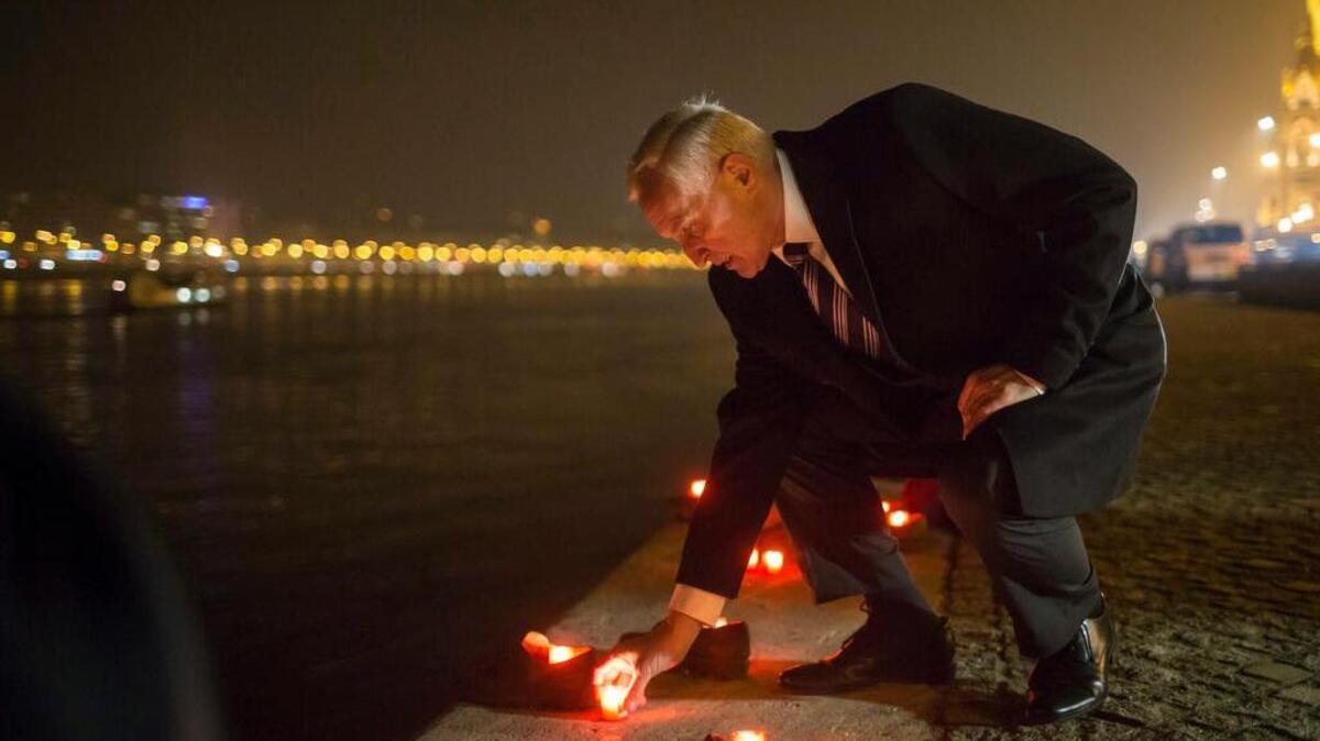 Hungarian Secretary of State for Security Policy and International Cooperation Istvan Mikola lights a candle in front of the cast iron shoes at the Holocaust Memorial on the quay of the River Danube, during International Holocaust Remembrance Day in Budapest, Hungary.