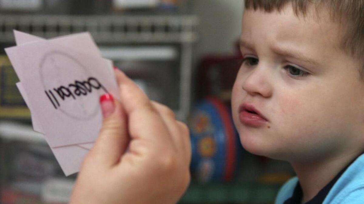 Jacob Day, 3, who is autistic, studies a flash card held by his instructional assistant at his home in Antelope, Calif.. At 18 months old, Jacob was formally diagnosed with autism, about a year earlier than usual. Before he turned 2, he began daily intensive behavior treatment designed to help him lead a more normal life.
