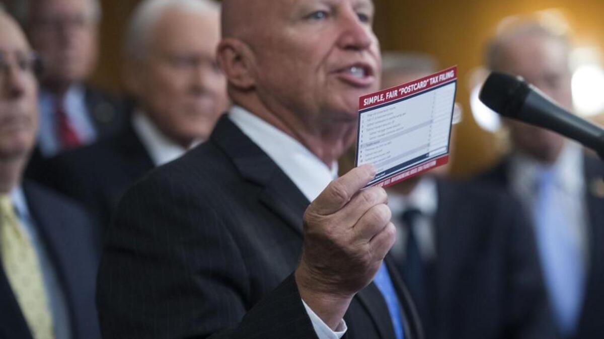 Rep. Kevin Brady, R-Texas, holds a tax filing "postcard" during an announcement in the Capitol's Rayburn Room on a tax reform proposal with Republican House and Senate leaders on Sept. 27, 2017. Republicans on Thursday gave final approval to a 2018 GOP budget resolution.